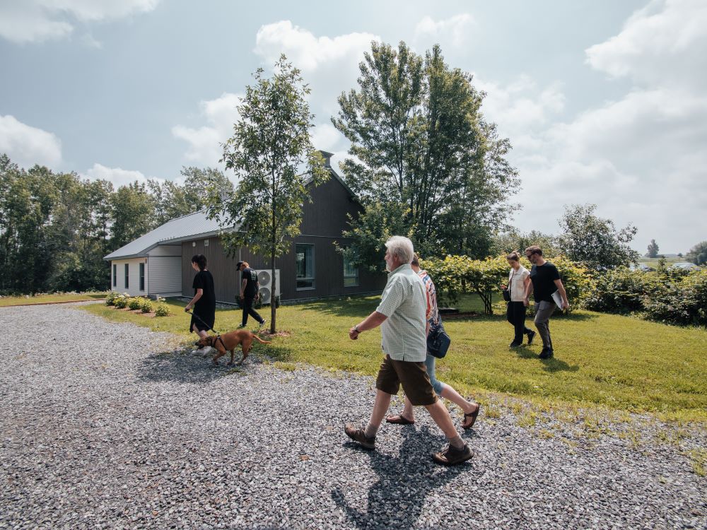 Groupe de personnes qui marchent devant une maison écologique